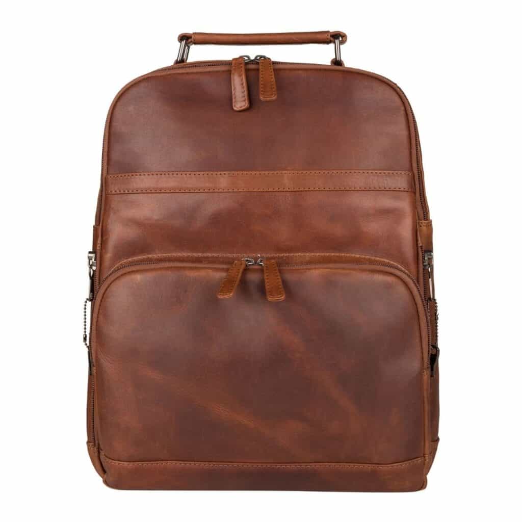 A brown leather backpack with two zippered front compartments and a top handle, photographed against a plain white background.